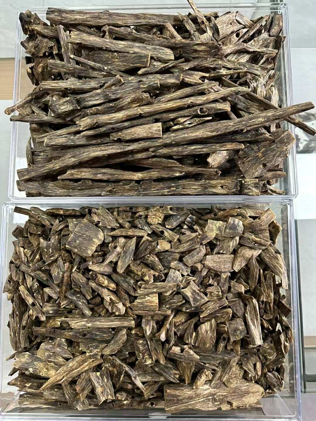 High-quality Agarwood (Oud) resin wood pieces showcasing natural dark grains and aromatic texture.